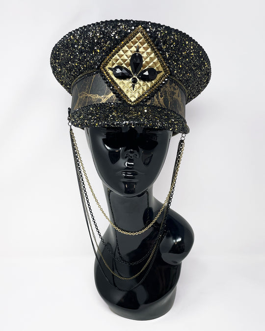 Authentic up cycled military captain hat, fully lined, hand embellished with black and gold glitter mix, beautifully hand detailed with gold and brown marble effect faux leather, gold leatherette, crystals and rhinestones. costume hat, festival hat, festival outfit, statement hat, high end hats, high end party wear, where to buy captain hats, stage wear, unique fashion, custom stage wear, festival essentials, festival headwear, halloween outfit, burning man hat, army hat, made in the UK