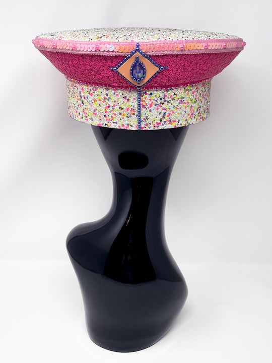 Festival captain hat with pink sequins, colourful glitter peak, Jukebox logo jewel detail, and glow-in-the-dark reflective starburst design – perfect for rave, costume, or party wear. Festival 
fashion,, stage wear