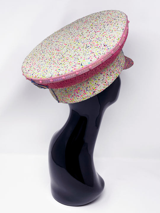 Festival captain hat with pink sequins, colourful glitter peak, Jukebox logo jewel detail, and glow-in-the-dark reflective starburst design – perfect for rave, costume, or party wear. Festival 
fashion,, stage wear