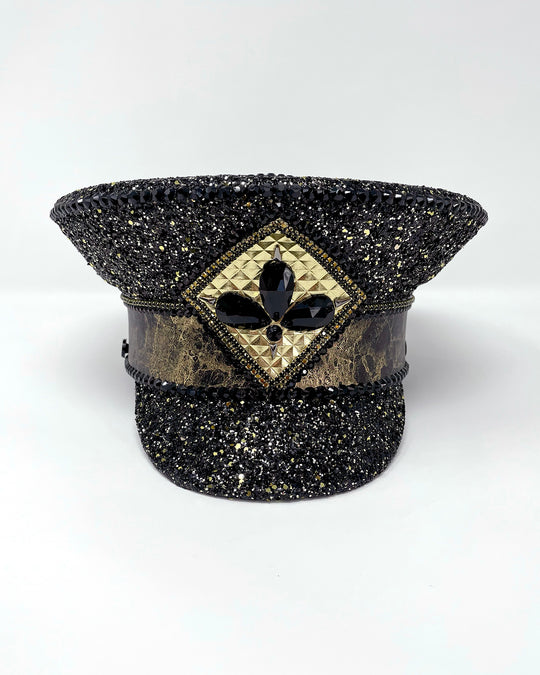 Authentic up cycled military captain hat, fully lined, hand embellished with black and gold glitter mix, beautifully hand detailed with gold and brown marble effect faux leather, gold leatherette, crystals and rhinestones. costume hat, festival hat, festival outfit, statement hat, high end hats, high end party wear, where to buy captain hats, stage wear, unique fashion, custom stagewear, festival essentials, festival headwear, halloween outfit, burning man hat, army hat, made in the UK